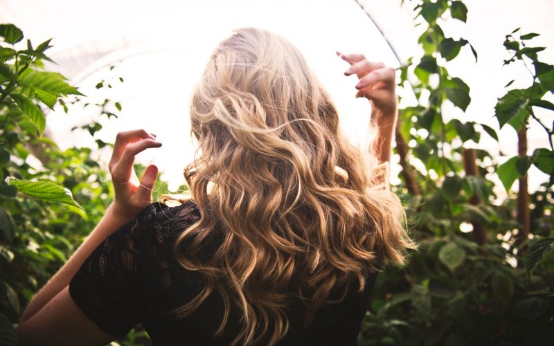 blonde-haired-woman-standing-between-green-plants-1049687